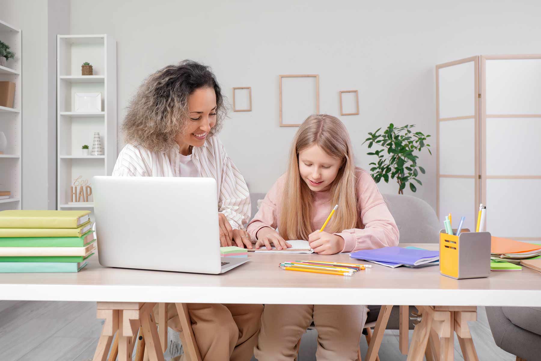 A female tutor helping a young student with schoolwork during a tutoring session